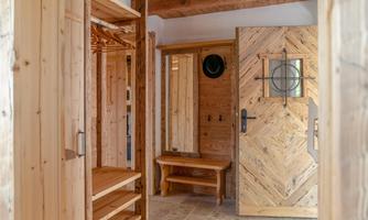 An inviting entry area made of wood with a beautiful wooden door and a practical seating area. The warm colors and natural wood look create a cozy atmosphere.