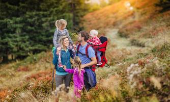 A happy family hiking in a colorful autumn landscape. The children enjoy nature while the parents accompany them.