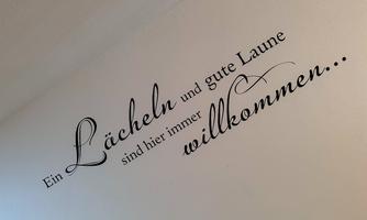 A wall text that looks inviting. It says: “A smile and good cheer are always welcome here...”.