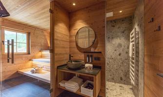 A cozy sauna with wooden paneling and a modern shower. The room is brightly and invitingly designed.