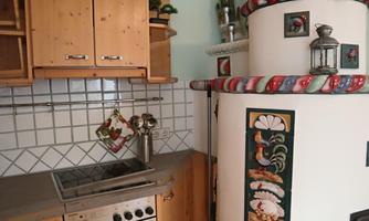 A cozy kitchen with wooden cabinets and a traditional stove. The countertop is modern and tidy.