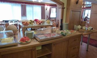 A buffet with fresh fruits and various dishes. The room is bright and inviting, perfect for a breakfast.