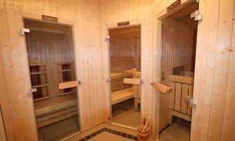 Three separate sauna cabins made of light wood. The room is warm and inviting, ideal for relaxation and wellness.