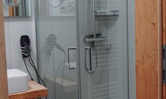 A modern shower with a glass partition and high-quality fittings. The room is bright and friendly designed.