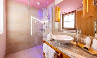 A modern bathroom with an open shower and an elegant vanity top. The walls are in soft colors and the lighting creates a welcoming atmosphere.