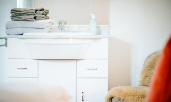 A modern sink with clean towels and personal care products. The bright, friendly environment creates a relaxed atmosphere.