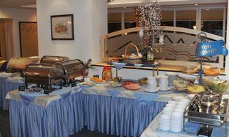 A buffet with various dishes and snacks. The table is decorated with blue tablecloths and provides an inviting atmosphere.