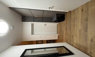 A bright hallway with a mirror on the wall and wooden flooring. On the right side, there is a seating area and a door leading to another room.