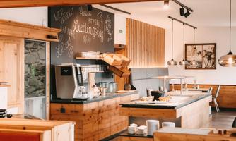 A modern kitchen with wood paneling and an elegant buffet. The walls are decorated with chalkboard graphics that create an inviting atmosphere.