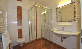 A modern bathroom with a glass shower. It features a sink and elegant floor tiles.