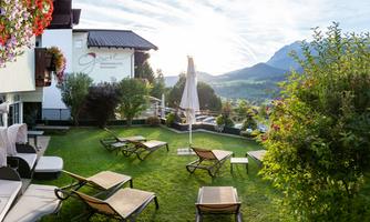A beautiful garden with loungers and a view of the mountains. The atmosphere is calm and inviting.