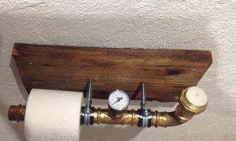 A creative holder for toilet paper made of pipes and wood. In the center, there is a manometer for pressure display.