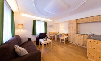 A cozy apartment with a sofa and a table. The bright walls and wooden furniture create a friendly atmosphere.