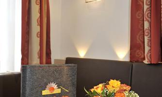 An inviting table in a restaurant with a menu and a beautiful flower vase. The warm colors and lighting create a cozy atmosphere.