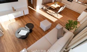 A modern living room with bright parquet flooring and a cozy sofa. The dining area is well-lit and invites you to linger.