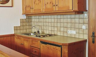 A cozy wooden kitchen with modern appliances. The space is designed to be bright and inviting.