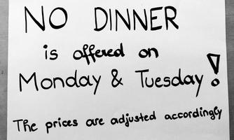 A sign informs that dinner is not offered on Monday and Tuesday. The prices will be adjusted accordingly.