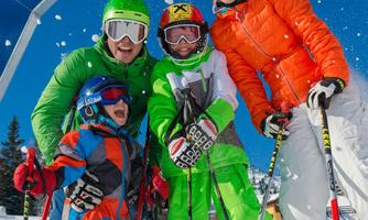 A cheerful family stands on a ski slope in the snow. They are wearing colorful ski clothing and posing in front of a sign that reads "FUNSLOPE".