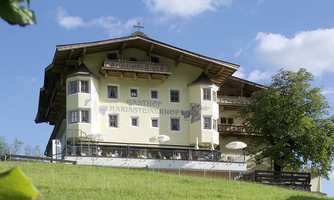 A beautiful house on a green meadow under a blue sky. Surrounded by trees, the scene radiates tranquility and idyll.