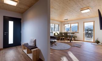 A modern living space with handcrafted wooden details. The large windows offer a beautiful view and plenty of daylight.