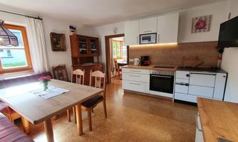 A bright and inviting kitchen with a dining area and modern amenities. The space features large windows and a cozy atmosphere.