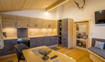 A modern wooden kitchen with a dining table and chairs. The decor feels cozy and inviting.