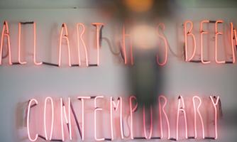 A neon light installation with the inscription "ALL ART HAS BEEN CONTEMPORARY". The text is in pink light and conveys a modern atmosphere.
