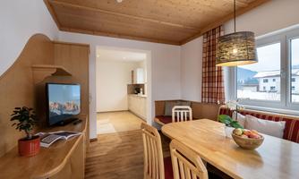 Cozy dining area with large table and TV.