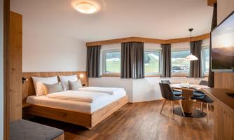 Modern studio with a double bed and a cozy dining area.  
Generous windows provide plenty of light and a gorgeous view of the surrounding mountain landscape.