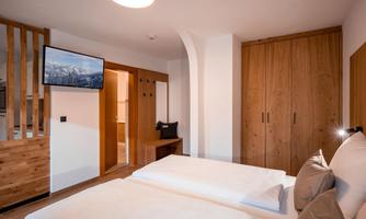 Studio with a double bed and a television.