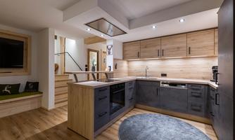 Modern kitchen with wood and gray elements. Bright lighting and an open space concept create an inviting atmosphere.