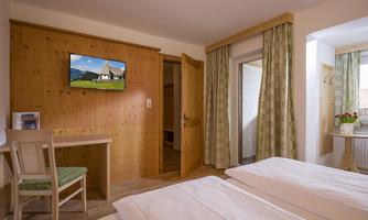 Bedroom with double bed, TV, and its own small balcony.