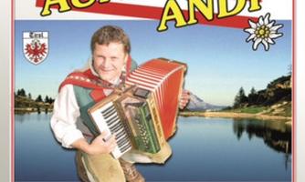 A cheerful musician with an accordion smiles at the camera. In the background, mountains and water can be seen.