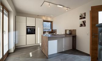 A modern kitchen with bright walls and an elegant kitchen island. The room is well-lit and has large windows.