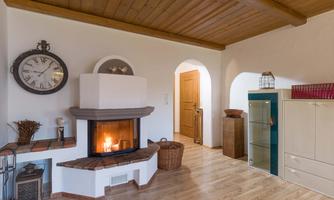 A cozy living room with a fireplace and wooden floor. Soft colors and a rustic style create an inviting atmosphere.