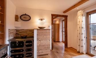 A cozy kitchen with wooden details and a classic stove. Large windows provide plenty of natural light and create an inviting space.