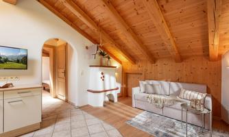 A cozy living space with a wooden ceiling and modern furniture. A television and a bright atmosphere give the room an inviting touch.