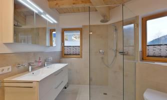 A modern bathroom with a spacious shower and a large mirror. Bright colors and wooden accents create an inviting atmosphere.