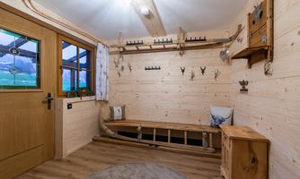 An inviting entrance area with wood paneling and a cozy bench seating. The walls are adorned with various decorative elements.