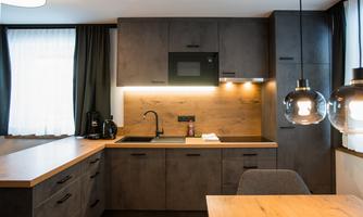 Modern kitchen with a combination of dark cabinets and wooden surfaces. It is well-equipped and has a cozy atmosphere.
