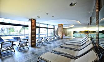 A modern wellness area with loungers and large windows. The atmosphere is calm and inviting, ideal for relaxation.