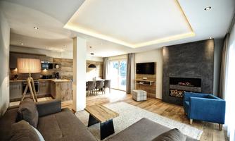 A modern living room with a cozy couch and an elegant table. The open kitchen and the fireplace create an inviting atmosphere.