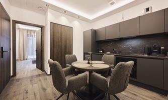 A modern kitchen with a round table and chairs. The room is stylishly furnished and well lit.