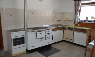 A practical kitchen with a combination of modern appliances and a classic stove. It is bright and feels welcoming.