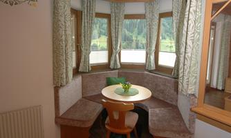 A cozy dining area with round windows and a beautiful view. The decor is modern and inviting, perfect for relaxed moments.
