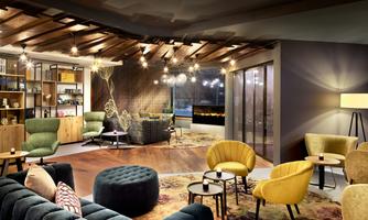 A modern living room with cozy armchairs and a stylish rug. The lighting creates an inviting atmosphere.