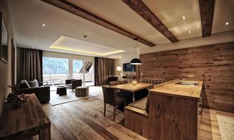 A modern apartment with wood decor and large windows. The open living and dining area provides a cozy atmosphere.