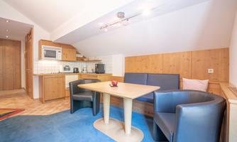 A cozy kitchen corner with a table and two chairs. The wooden furniture and the bright decor create a relaxed atmosphere.