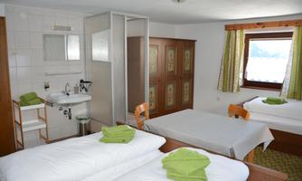 A cozy room with two beds and a washing area. The bright colors and towels create an inviting atmosphere.