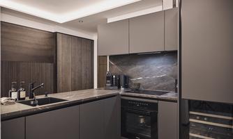 Modern kitchen with elegant gray cabinets and a stylish marble countertop. The atmosphere is bright and inviting due to the subtle lighting.